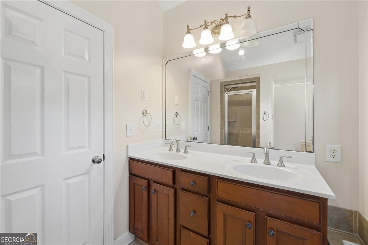 728 Markhams Drive Madison, GA 30650 - Photo 24 of 51 a bathroom with double vanity sinks a vanity a lamp and a mirror