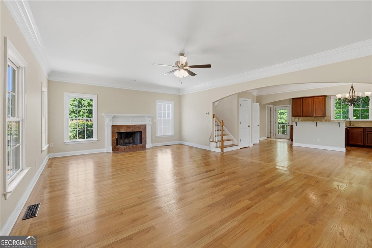 728 Markhams Drive Madison, GA 30650 - Photo 3 of 51 an empty room with wooden floor and a fireplace