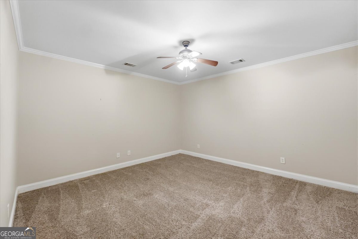 728 Markhams Drive Madison, GA 30650 - Photo 35 of 51 an empty room with a ceiling fan and wooden floor