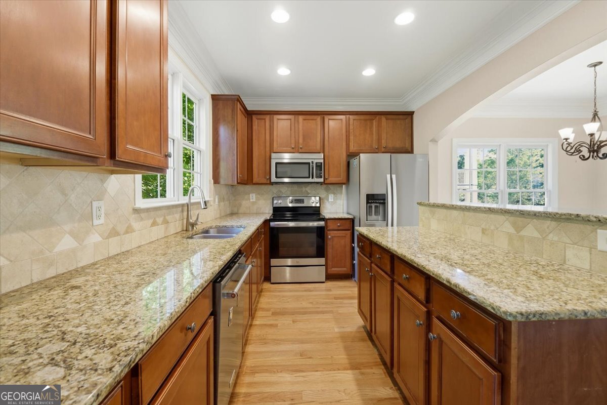728 Markhams Drive Madison, GA 30650 - Photo 9 of 51 a kitchen with stainless steel appliances granite countertop a sink stove and refrigerator