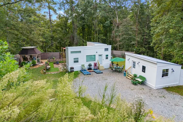 a view of a house with backyard and sitting area