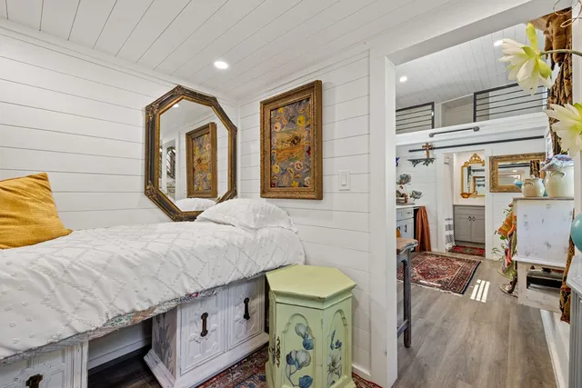 a view of a backyard with lawn chairs potted plants and large tree