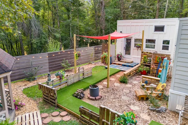 a backyard of a house with barbeque oven table and chairs