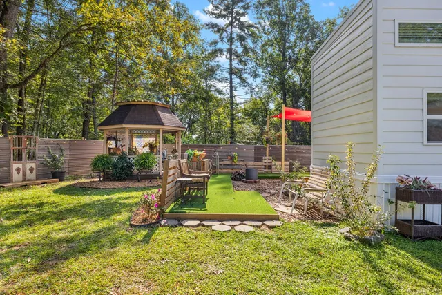 a view of a house with backyard and sitting area