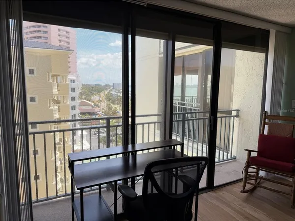 a view of a city from a dining room with wooden floor and windows
