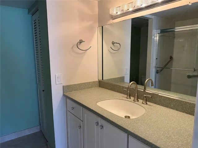 a bathroom with a granite countertop sink and a mirror