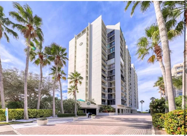 a front view of multi story residential apartment building with yard and sign board