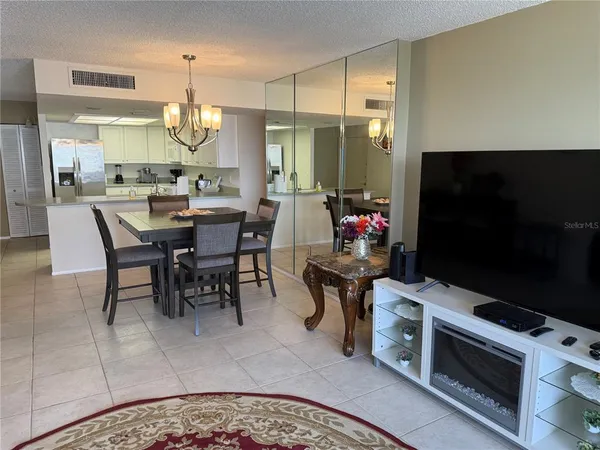 a kitchen with stainless steel appliances kitchen island granite countertop a table chairs sink and stove top oven