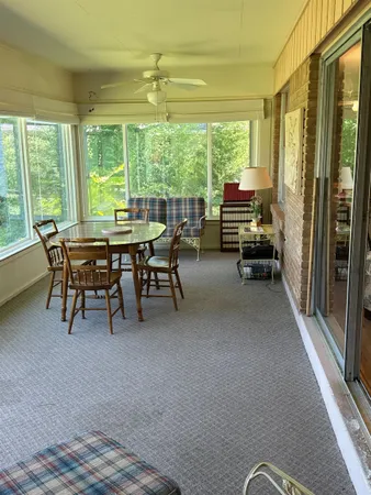 a dining room with furniture and a floor to ceiling window