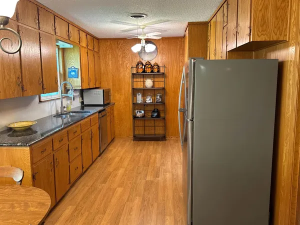 a kitchen with stainless steel appliances granite countertop a refrigerator and a sink