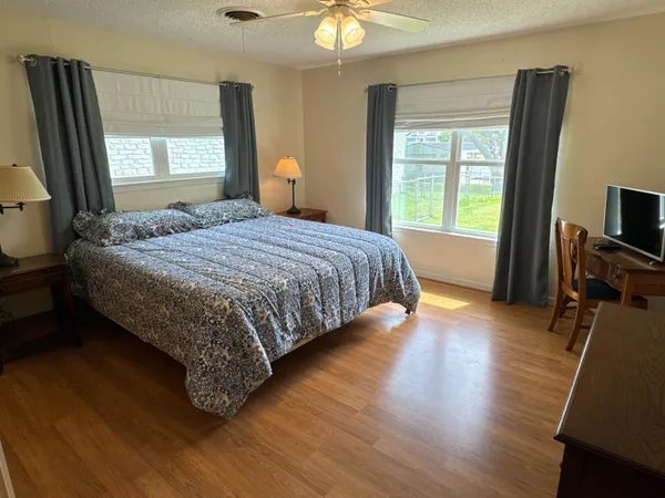 a bed sitting in a spacious bedroom next to a window