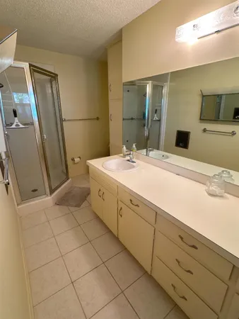 a bathroom with a sink a mirror and a shower