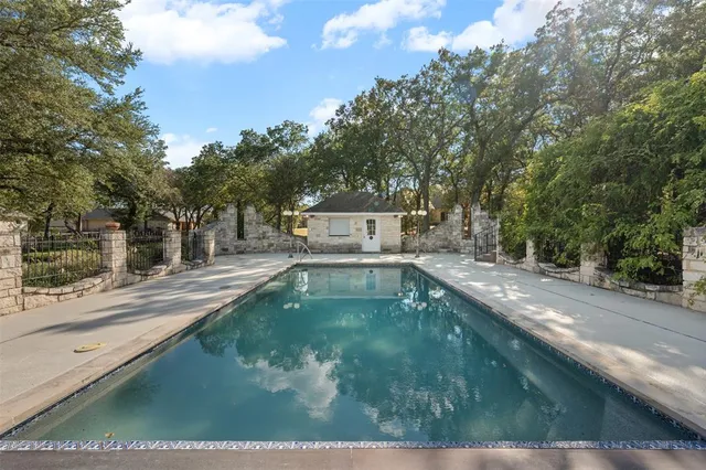 a view of a yard in front of a house with large trees