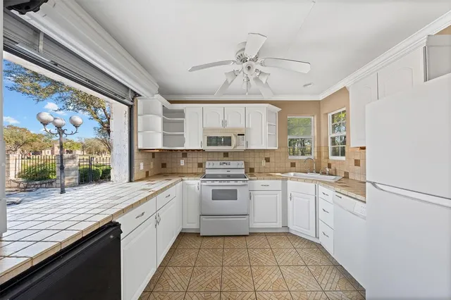 a kitchen with a granite countertop sink and a window