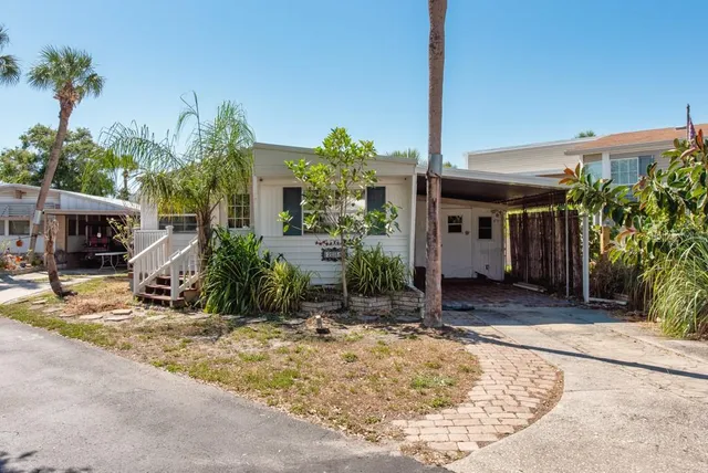 a view of a house with a yard and palm trees