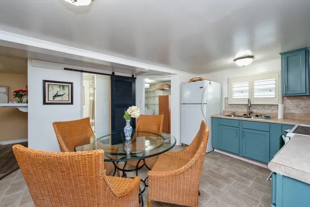 a living room with stainless steel appliances furniture a dining table and kitchen view