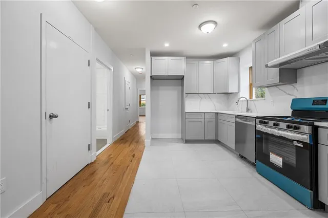 a kitchen with stainless steel appliances granite countertop a sink and a refrigerator