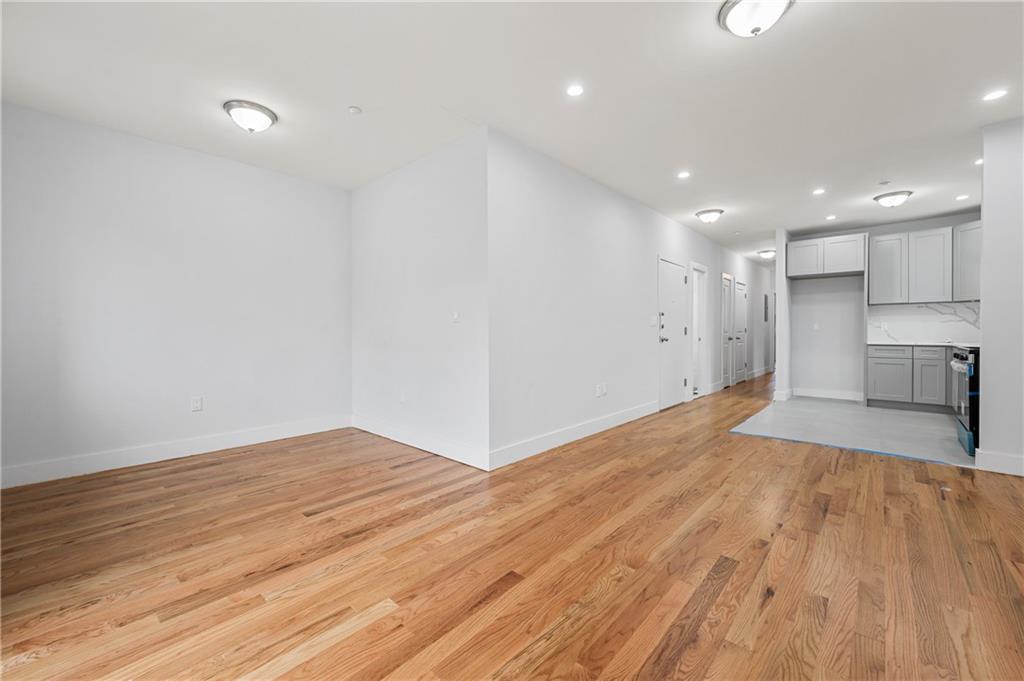 2167 West 13th Street Brooklyn, NY 11223 - Photo 22 of 35 a view of empty room with wooden floor and kitchen