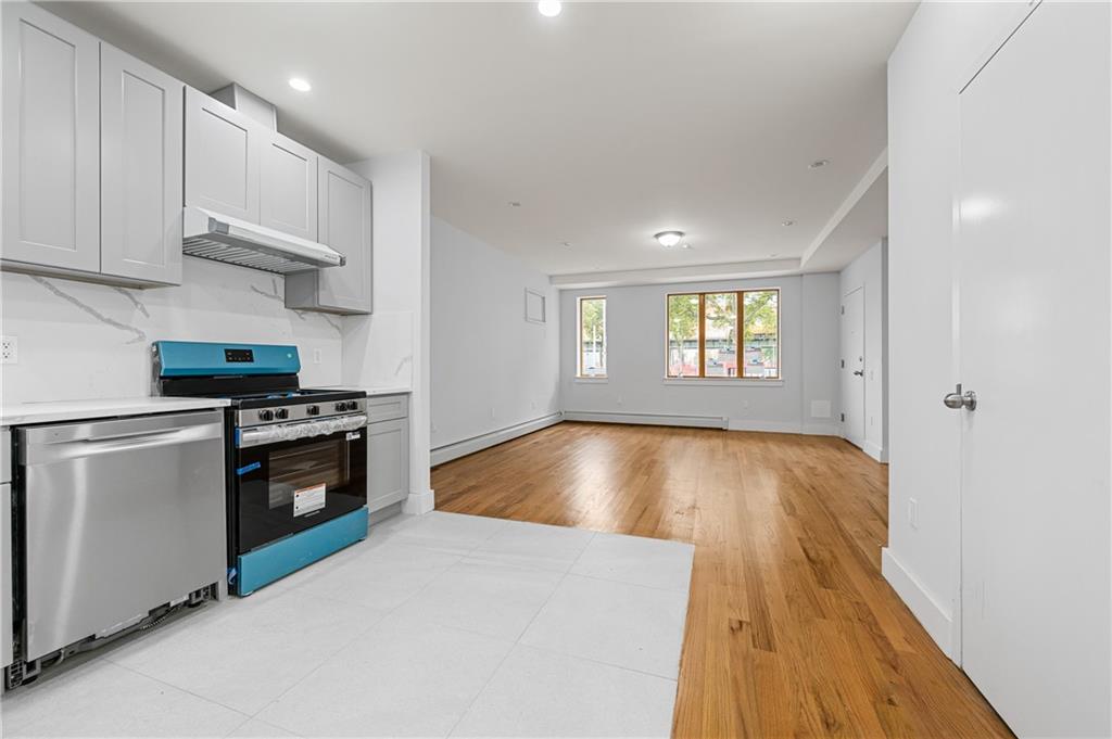 2167 West 13th Street Brooklyn, NY 11223 - Photo 23 of 35 a kitchen with a wooden floor and a stove top oven