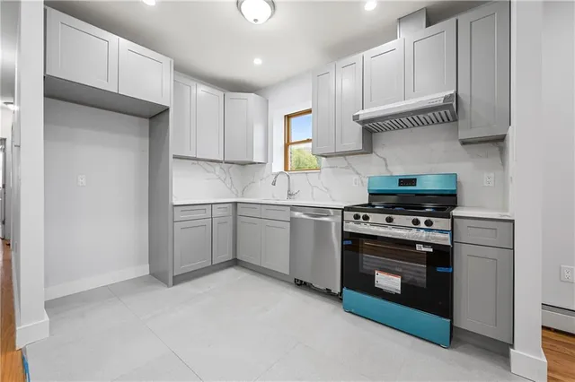 a kitchen with white cabinets and appliances