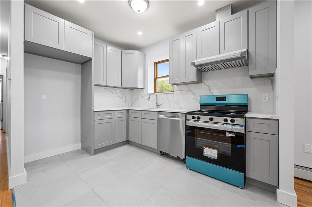 2167 West 13th Street Brooklyn, NY 11223 - Photo 24 of 35 a kitchen with white cabinets and appliances