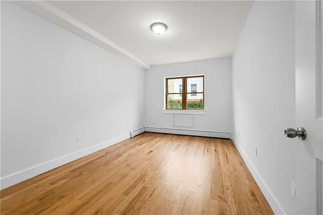 an empty room with a hardwood and windows