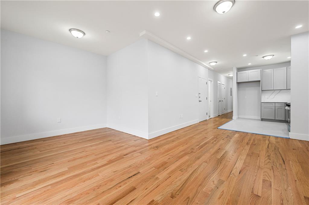 2167 West 13th Street Brooklyn, NY 11223 - Photo 4 of 35 a view of empty room with wooden floor and kitchen view