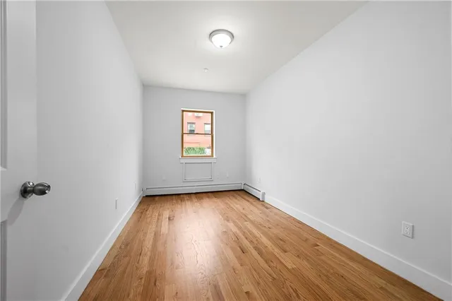 a view of a room with wooden floor and window