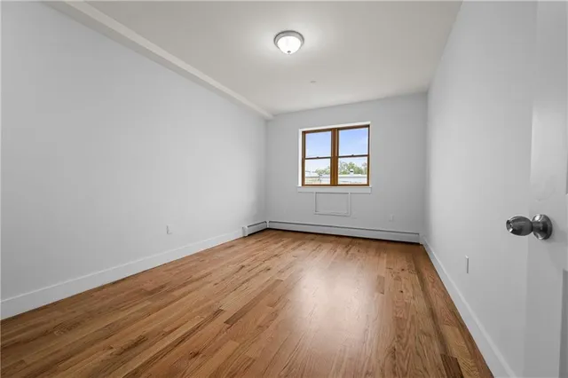 an empty room with a hardwood and windows