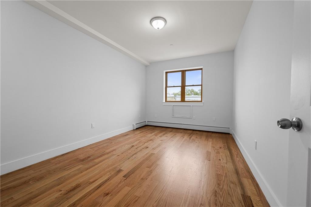 2167 West 13th Street Brooklyn, NY 11223 - Photo 8 of 35 an empty room with a hardwood and windows