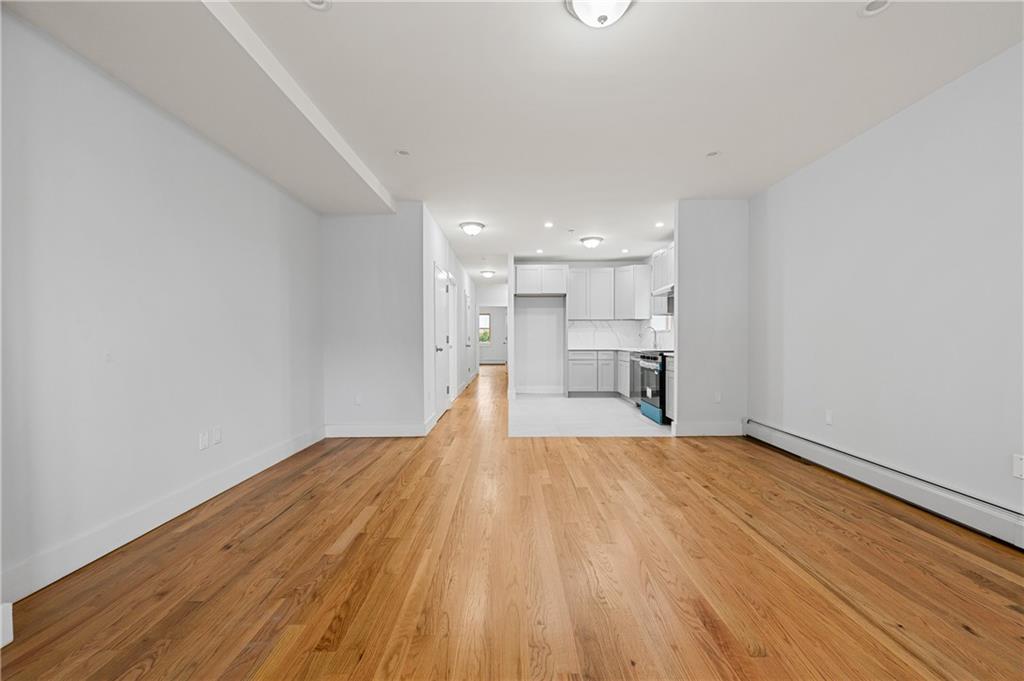 2167 West 13th Street Brooklyn, NY 11223 - Photo 10 of 35 a view of empty room with wooden floor and kitchen