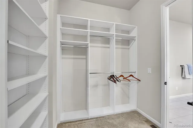 a view of walk in closet with empty racks