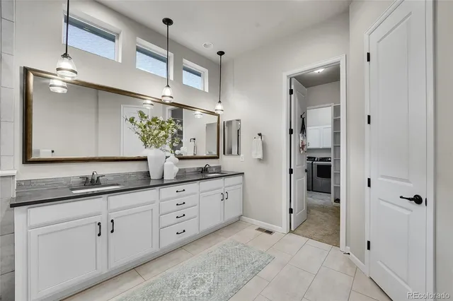 a spacious bathroom with double sink and a mirror