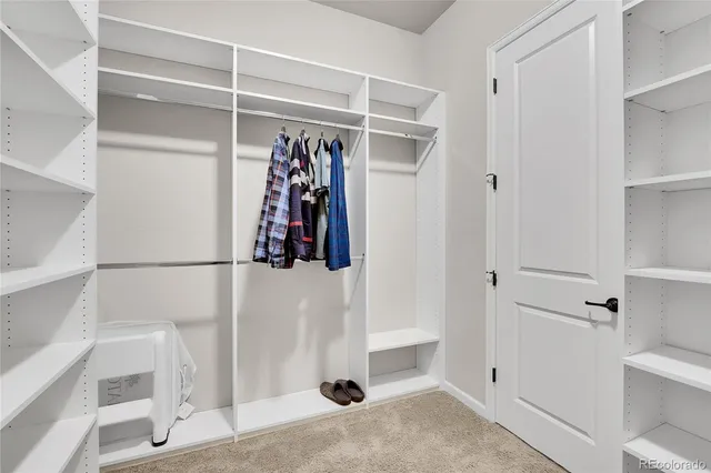 a view of walk in closet with clothes and shoes