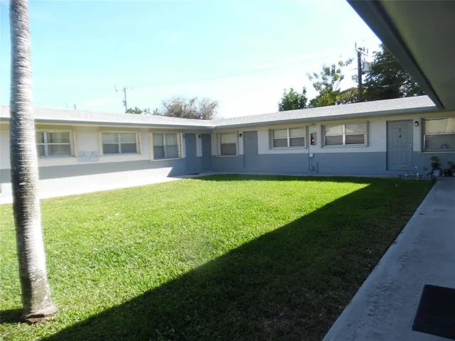 a view of a house with a big yard and potted plants