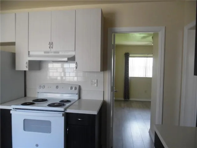 a kitchen with a stove sink and cabinets