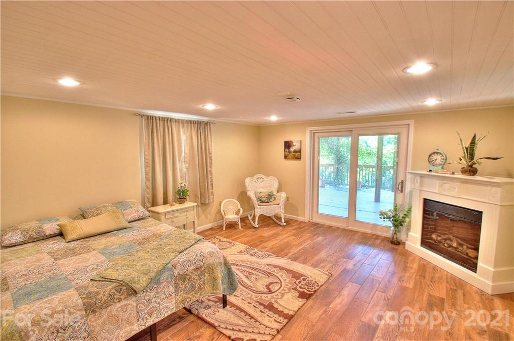 72 Slow Lane Canton, NC 28716 - Photo 22 of 47 a spacious bedroom with a large bed and a fireplace