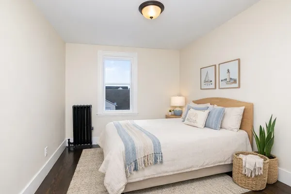 a bedroom with a bed and painting on the wall