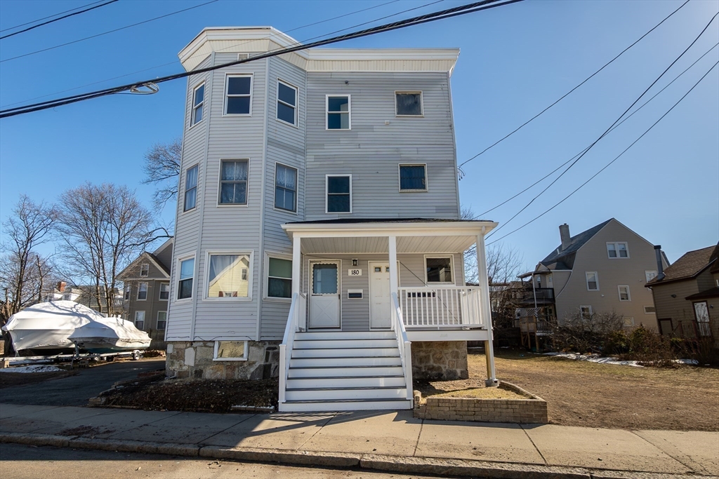 180 Shirley Street, Unit 3 Winthrop, MA 02152 - Photo 16 of 18 a view of a white house with large windows and a table and chairs