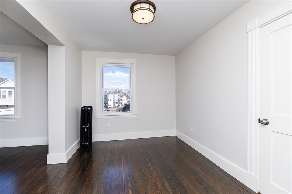 180 Shirley Street, Unit 3 Winthrop, MA 02152 - Photo 4 of 18 an empty room with wooden floor and window