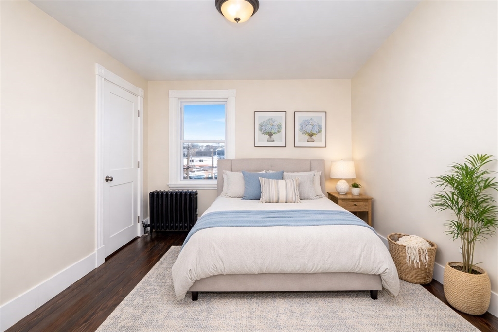 180 Shirley Street, Unit 3 Winthrop, MA 02152 - Photo 9 of 18 a bedroom with a bed lamp and a potted plant