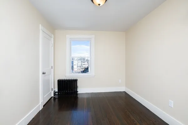 a view of room with window and wooden floor