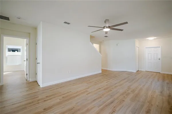 a view of an empty room with window and wooden floor