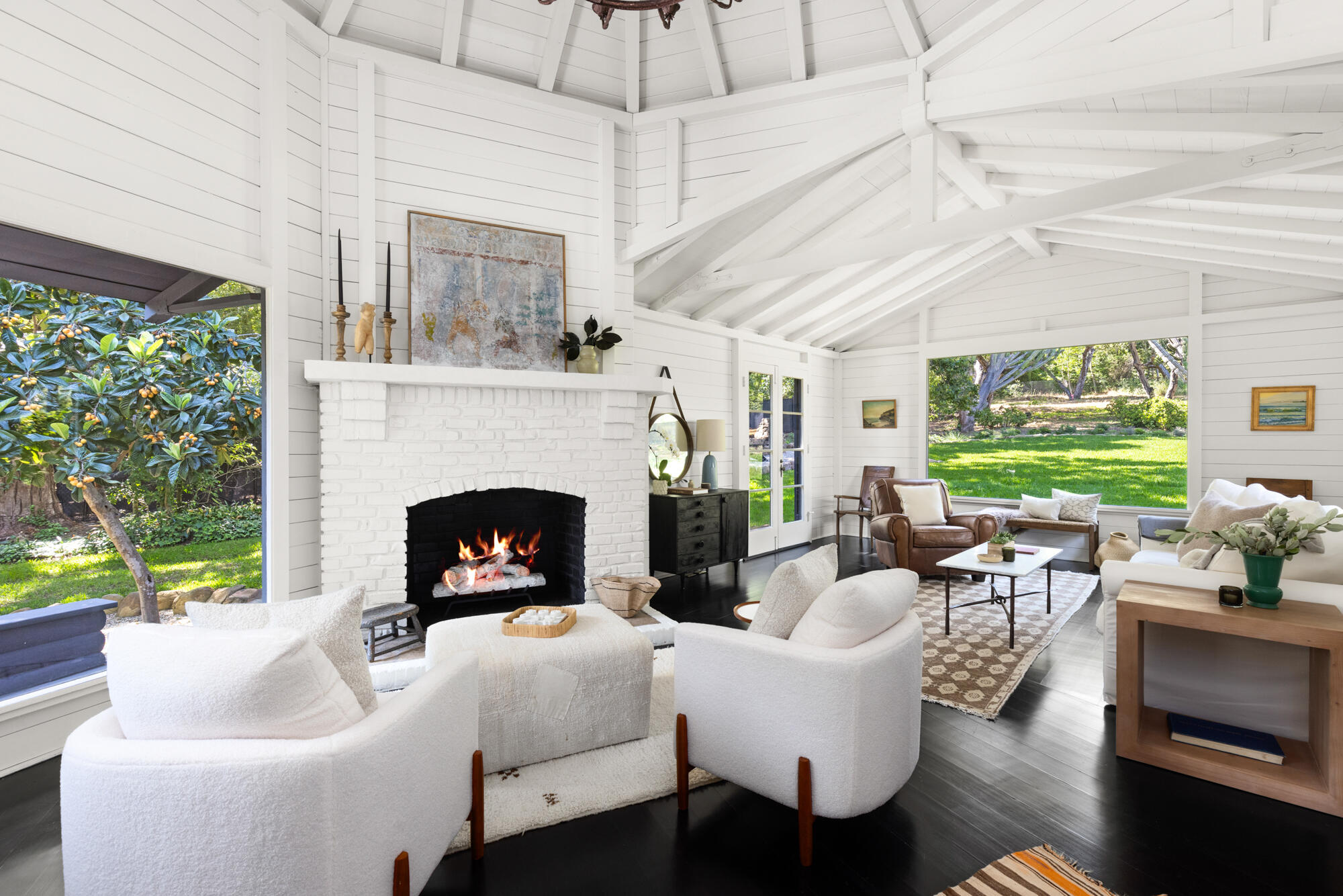 a living room with furniture a fireplace and a large window