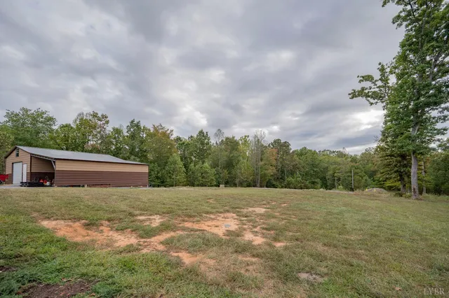 a aerial view of a house next to a big yard with large trees