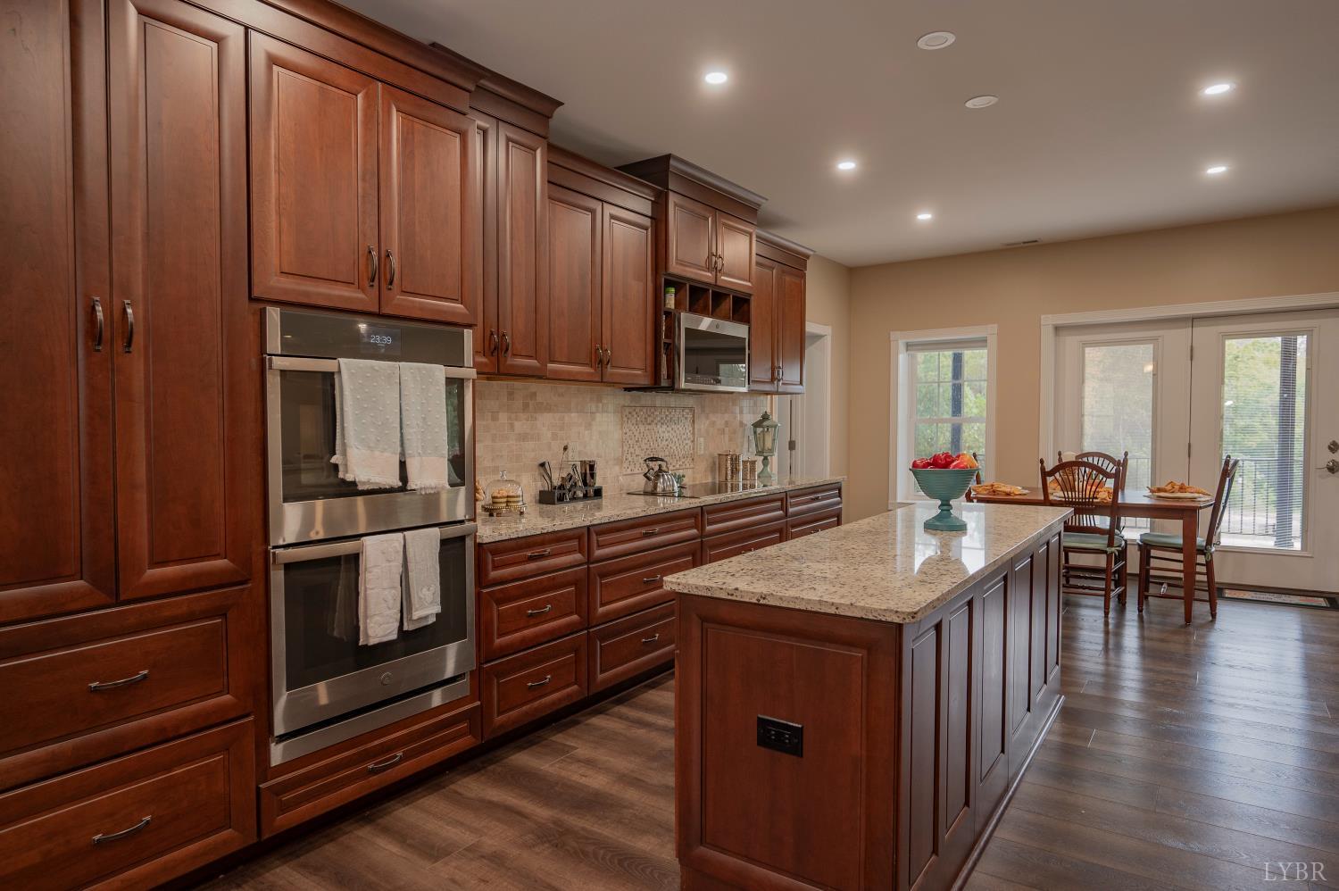 1080 Tranquility Lane Goode, VA 24556 - Photo 6 of 65 a kitchen with stainless steel appliances granite countertop a stove top oven a sink dishwasher a dining table and chairs with wooden floor