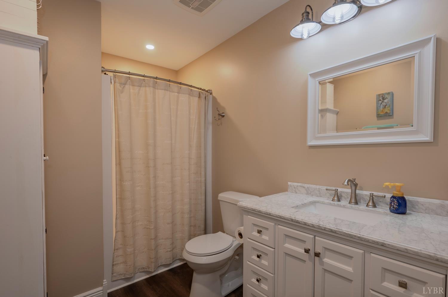 1080 Tranquility Lane Goode, VA 24556 - Photo 61 of 65 a bathroom with a granite countertop sink toilet and a mirror