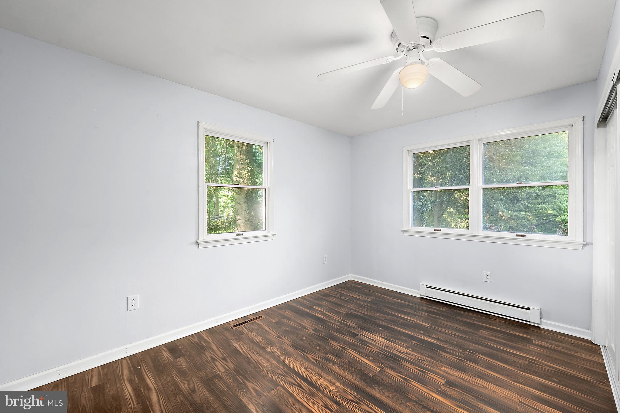 6181 Rockawalkin Road Salisbury, MD 21801 - Photo 27 of 65 an empty room with wooden floor ceiling fan and windows