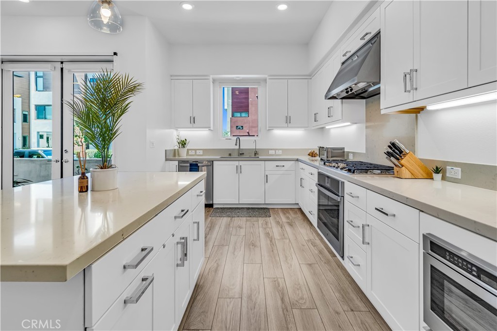 202 Waypoint Tustin, CA 92782 - Photo 14 of 46 a large kitchen with stainless steel appliances granite countertop a lot of counter space and wooden floor