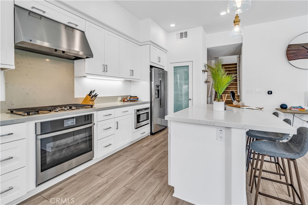 202 Waypoint Tustin, CA 92782 - Photo 15 of 46 a kitchen with stainless steel appliances a stove a sink and a microwave